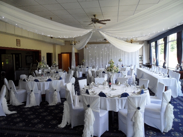 Wedding reception layout at Haydock Park Golf Club with ceiling drapes and fairylights