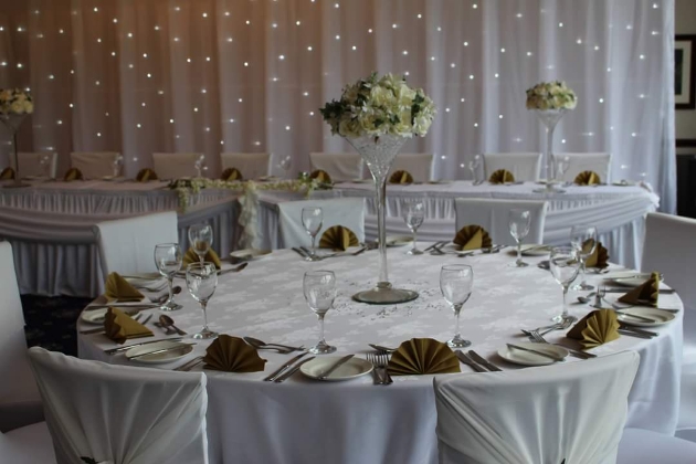 Wedding reception layout at Haydock Park Golf Club with flower-filled martini glass centrepieces