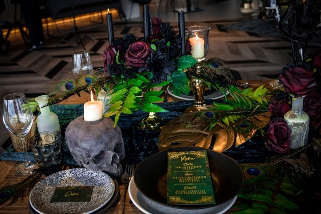 alternative wedding table scape complete with black candles and plates and skull candle holder