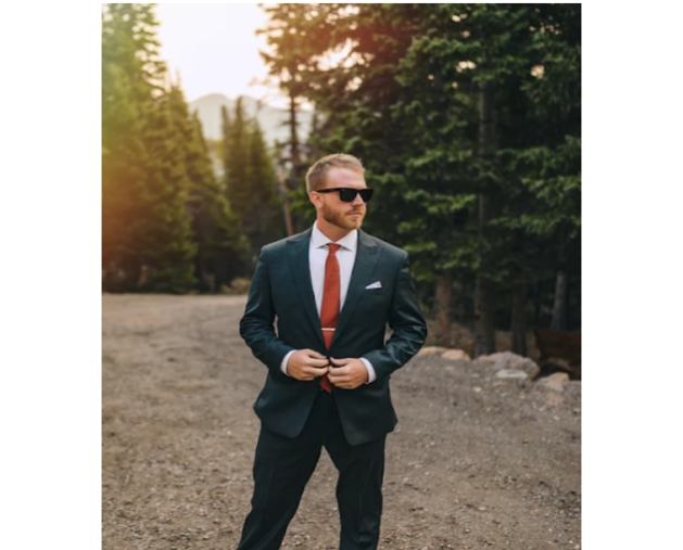 green suit on model standing in road at sunset