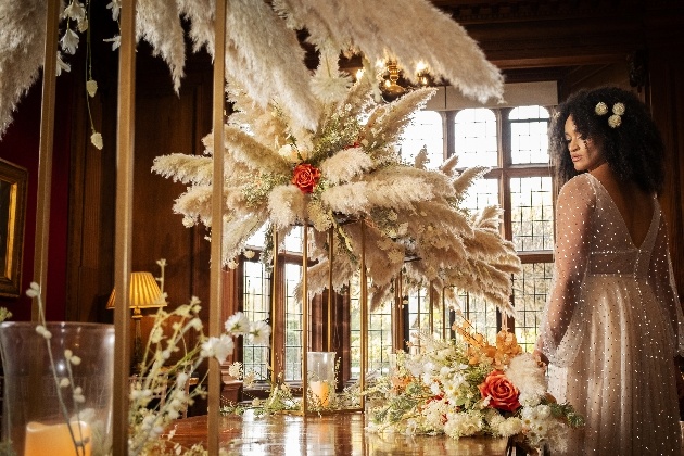Bride admiring wedding table set up with stunning pampas grass arrangements