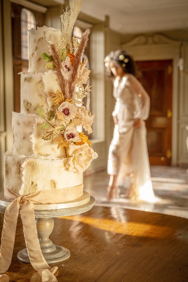 textured wedding cake decorated in sugar flowers and pampas grass