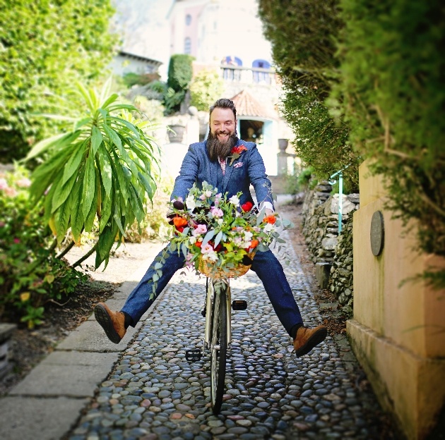 groom on a bicycle free wheeling down a cobbled street in portmerion