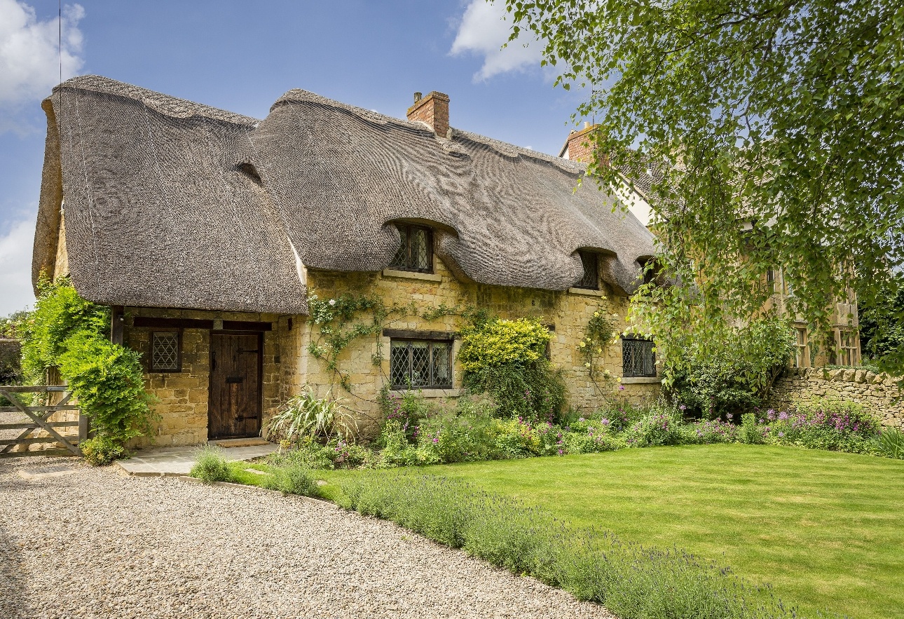 yellow stone traditional cottage with thatched roof picture-box style