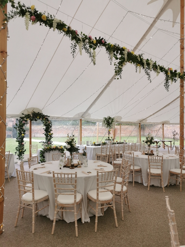 wedding marquee decorated in a white colour palette with hanging flower installation