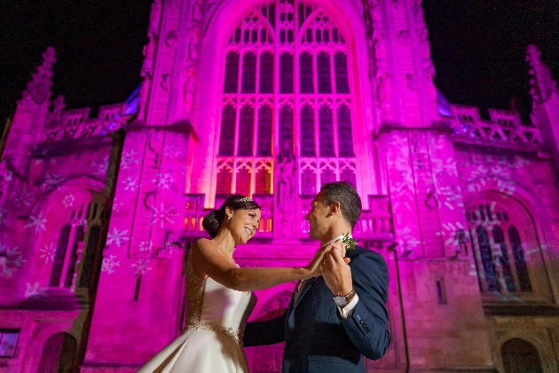 Bride and groom dancing in front of a cathedral