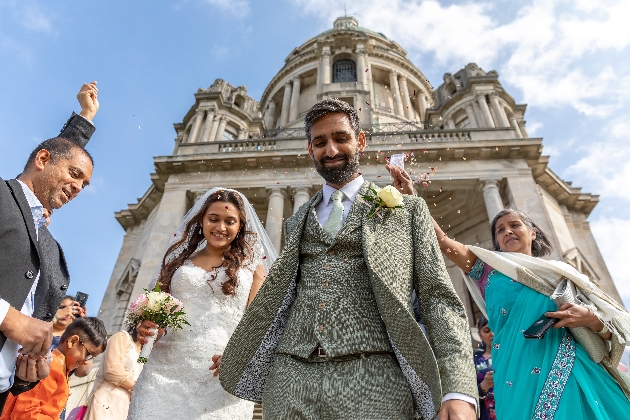 bride and groom having confetti thrown at them