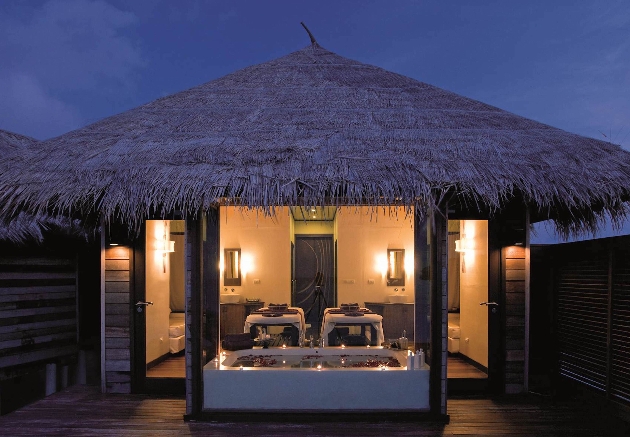 spa beds in room lit at night by candles