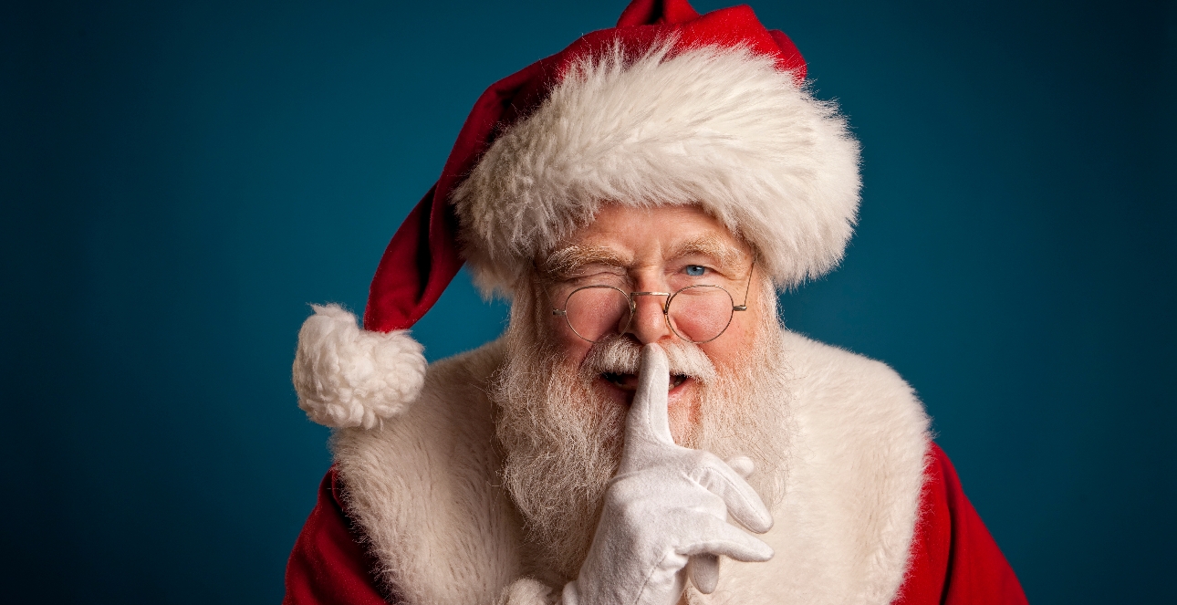 Father Christmas winking with a finger to his lips