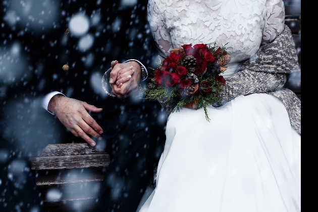 Bride and groom holding hands in the snow
