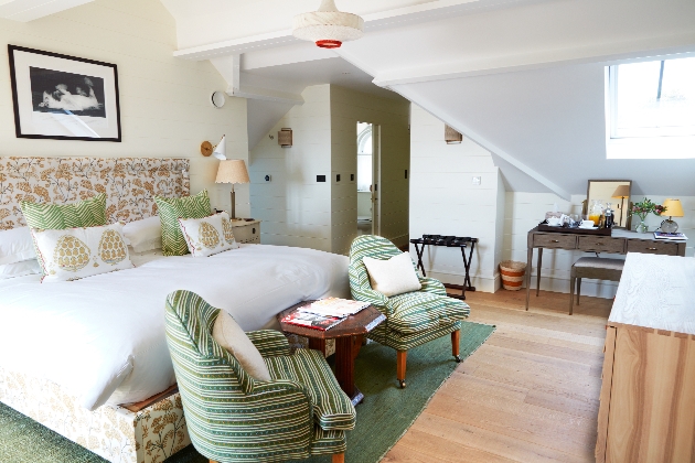 large bed in room with white walls and wooden floor