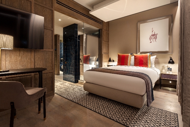modern bedroom with feature bed and tv on wall, neutral in colour palette and furnishings
