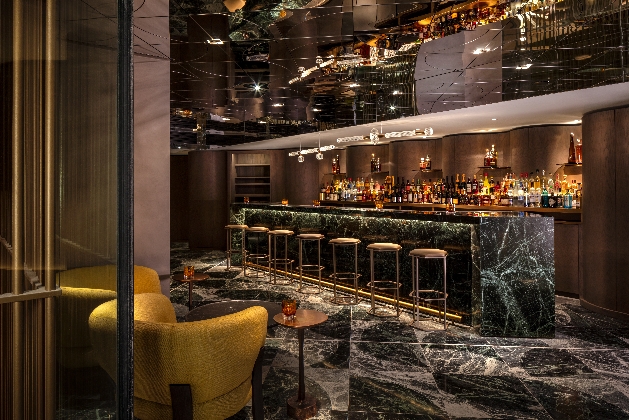 modern bar with marble bar side and top in green with gold bar stools
