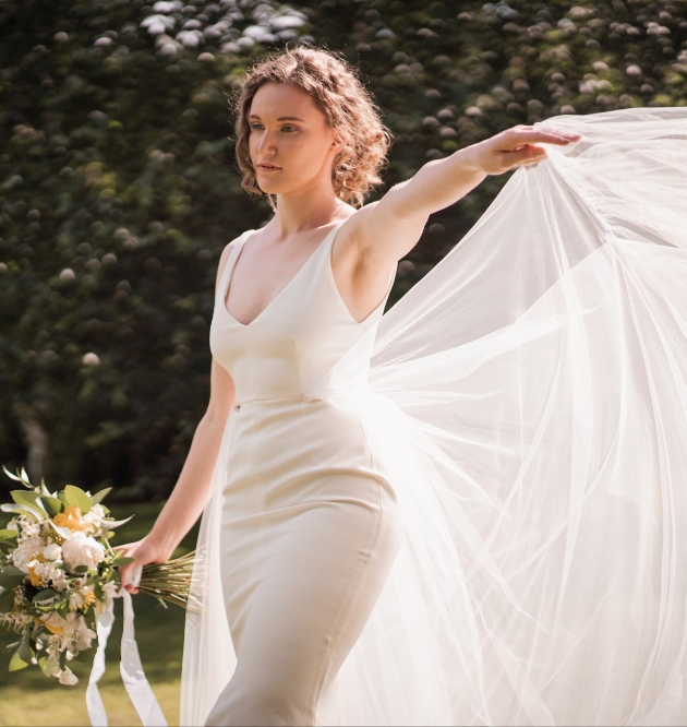 Bride wearing a form fitting gown with tulle overskirt