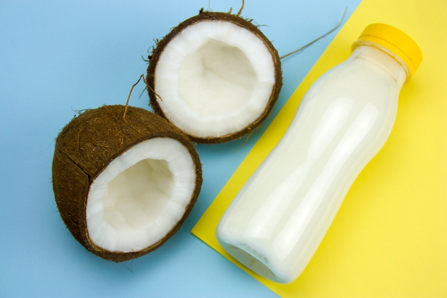 coconut and cocnut milk bottle on a yellow and blue background