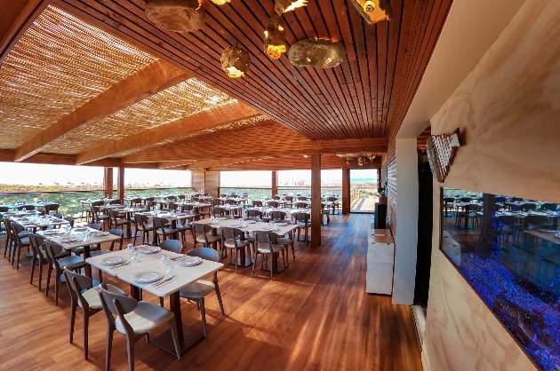 covered wooden terraced area with lots of tables and sea views