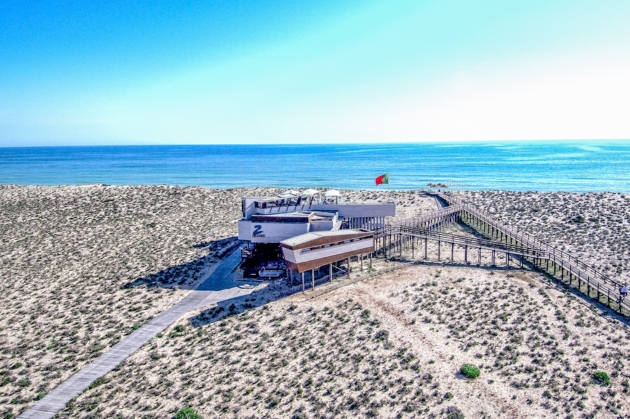 restaurant on stilts in the sand with sea views