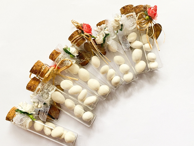 sugared almonds in test tube vials with cork lids and flowers attached 