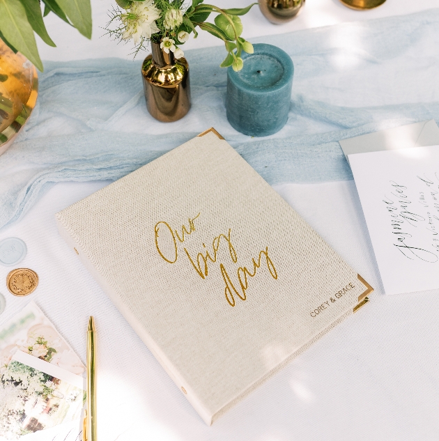 a material bound wedding planner with gold edges and gold writing say our big day