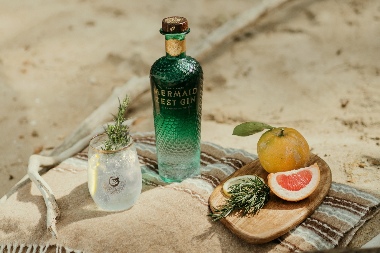 Mermaid Gin bottle on a picnic rug on the beach