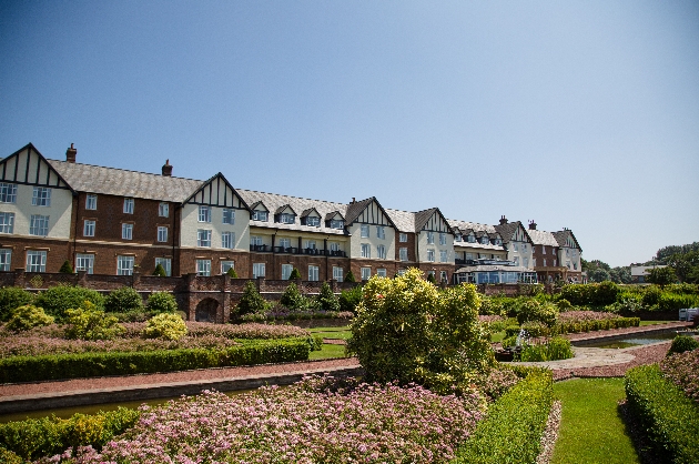 red and white facade of gold resort with gardens