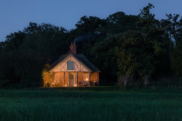 quaint cottage in a field at night
