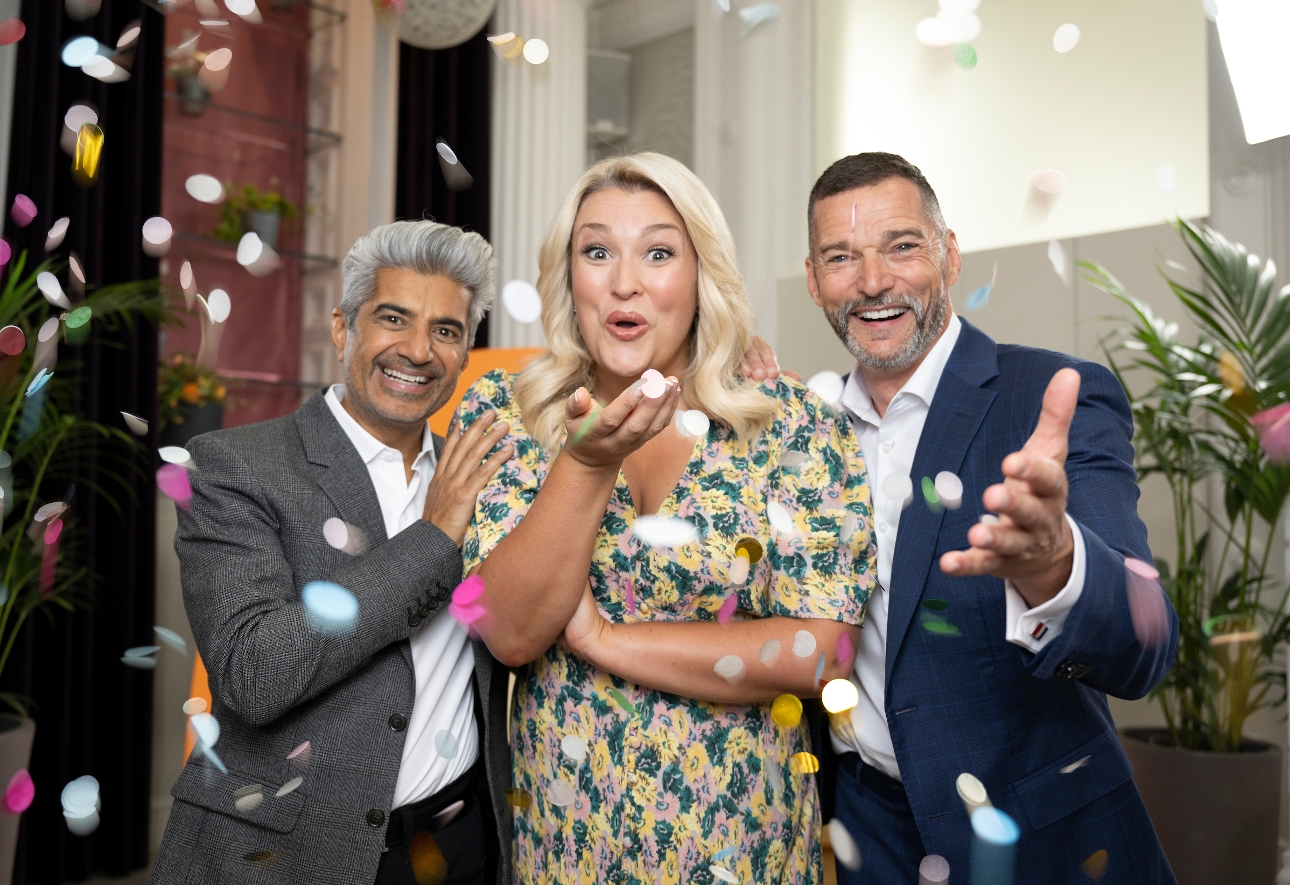 Sara Davies, Fred Sirieix and Raj Somaiya standing together blowing confetti