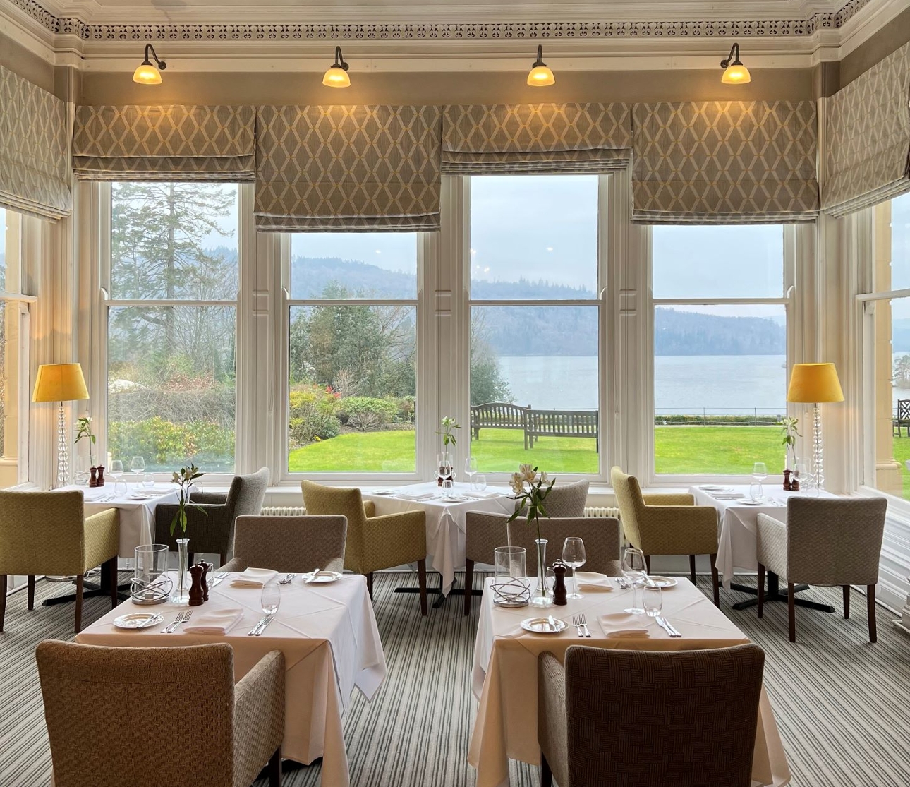 hotel restaurant neutral decor large windows with tables and chairs looking out to lake 