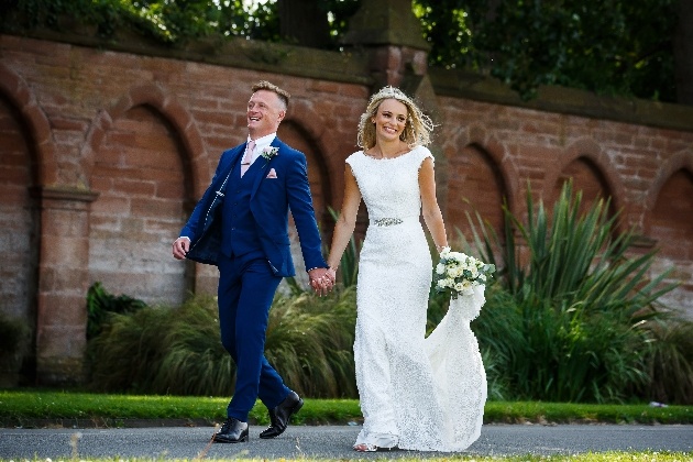 Bride and groom holding hands laughing