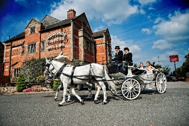 Bride and groom riding in a horse-drawn carriage