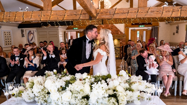 Bride and groom kissing at the altar having just said I do