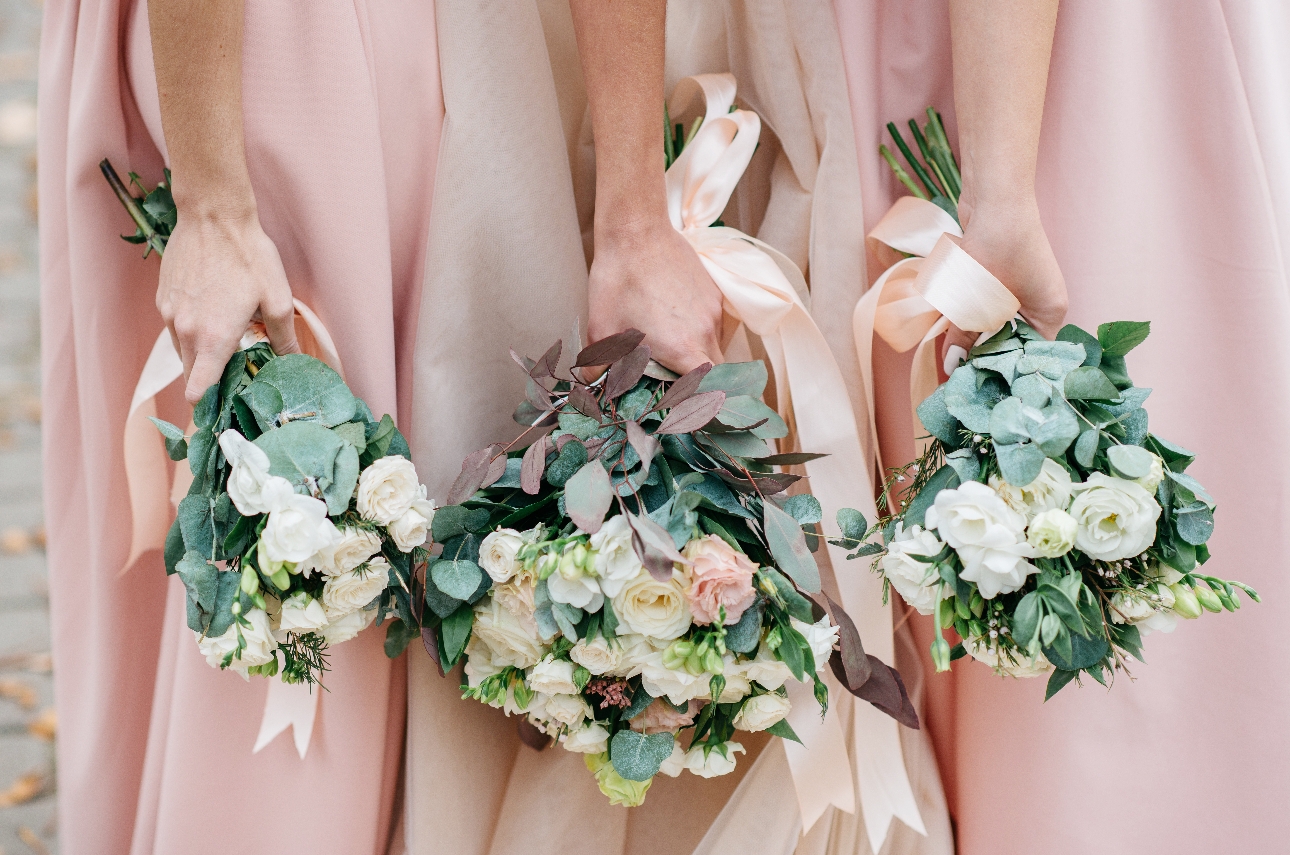 bride and bridesmaids holding bouquets of flowers