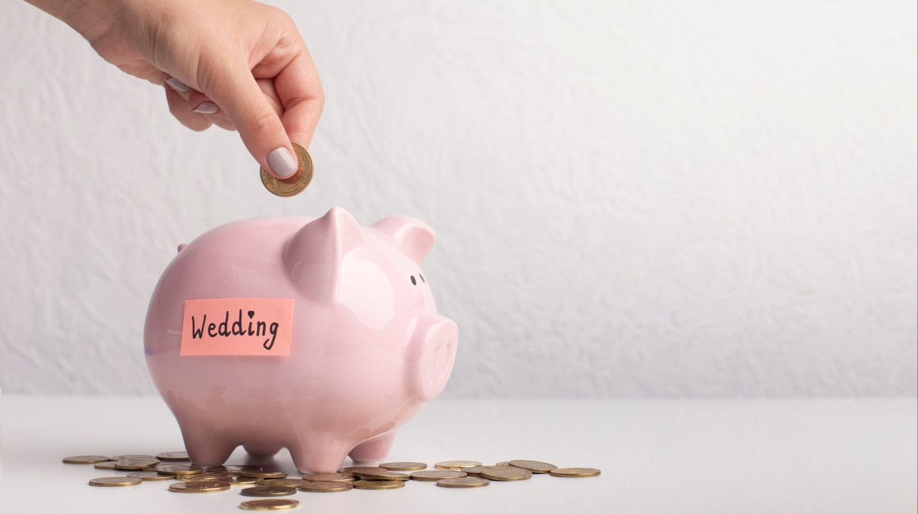 Saving pennies in a piggy bank labelled wedding