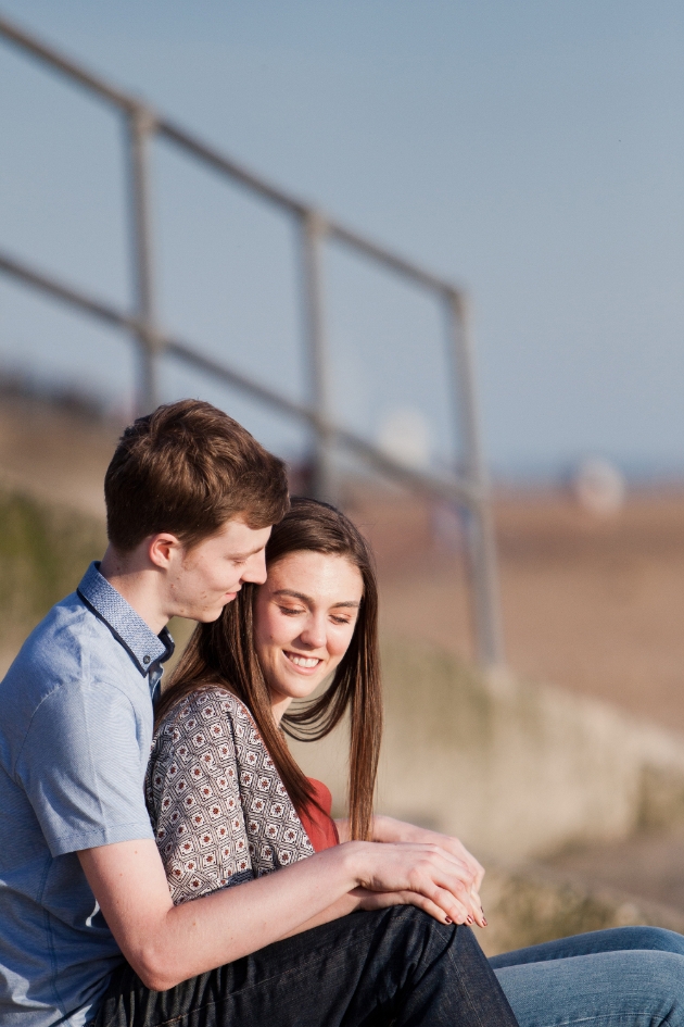 Engagement shoot couple sitting on the beach