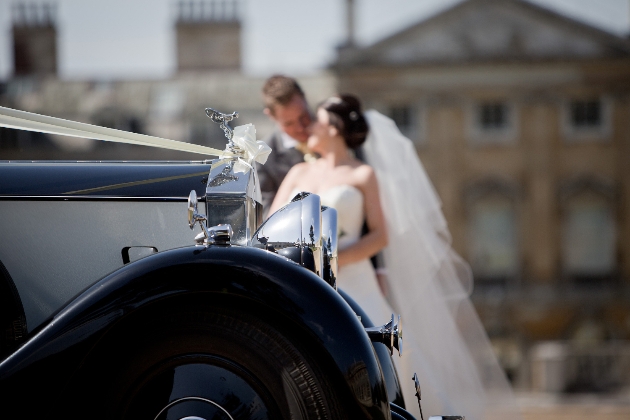 bride and groom in the background wedding car in foreground rolls royce