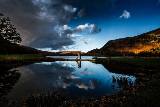 Bride and groom against a stunning backdrop of hills and lakes which steals the show