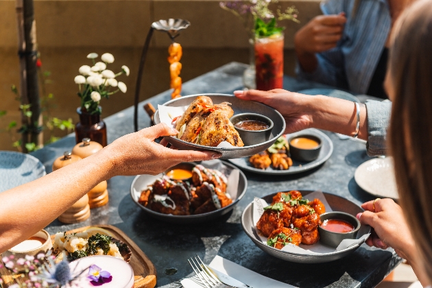 People passing over and sharing delicious dishes from the new menu at The Botanist