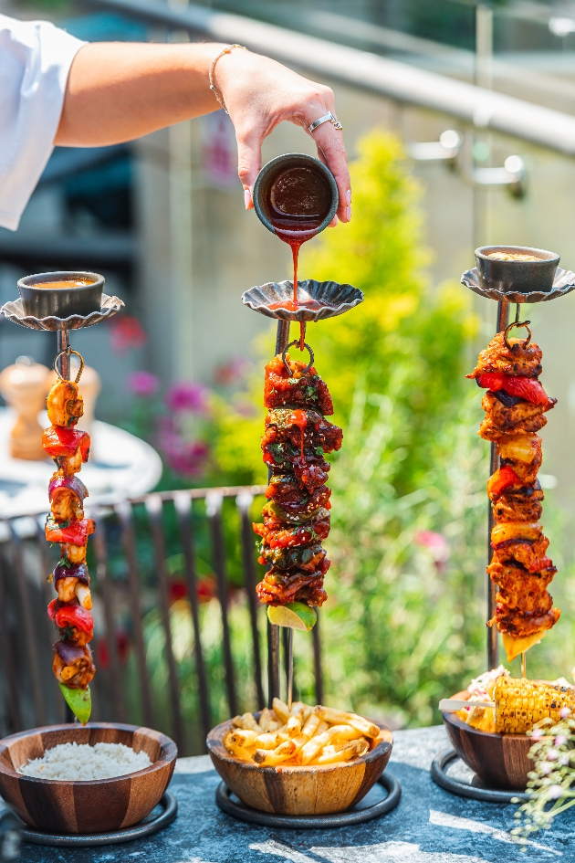 Popular hanging kebabs with sauce being poured on them at The Botanist