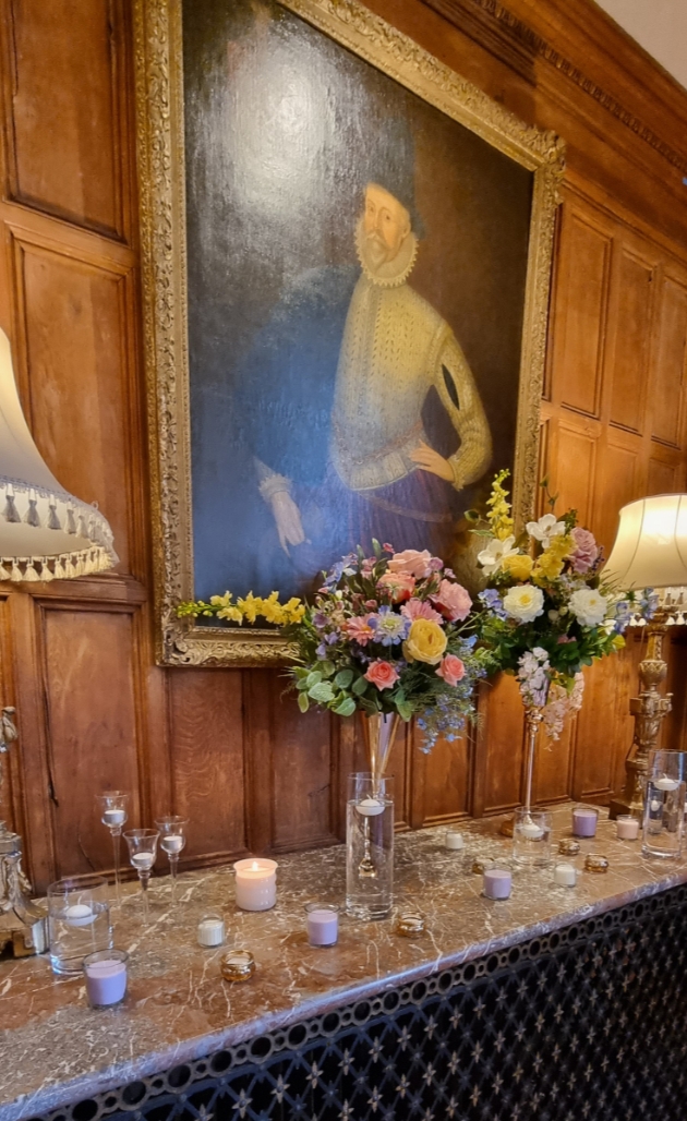 Regency vibe venue styling two tall floral arrangements on sideboard historical venue