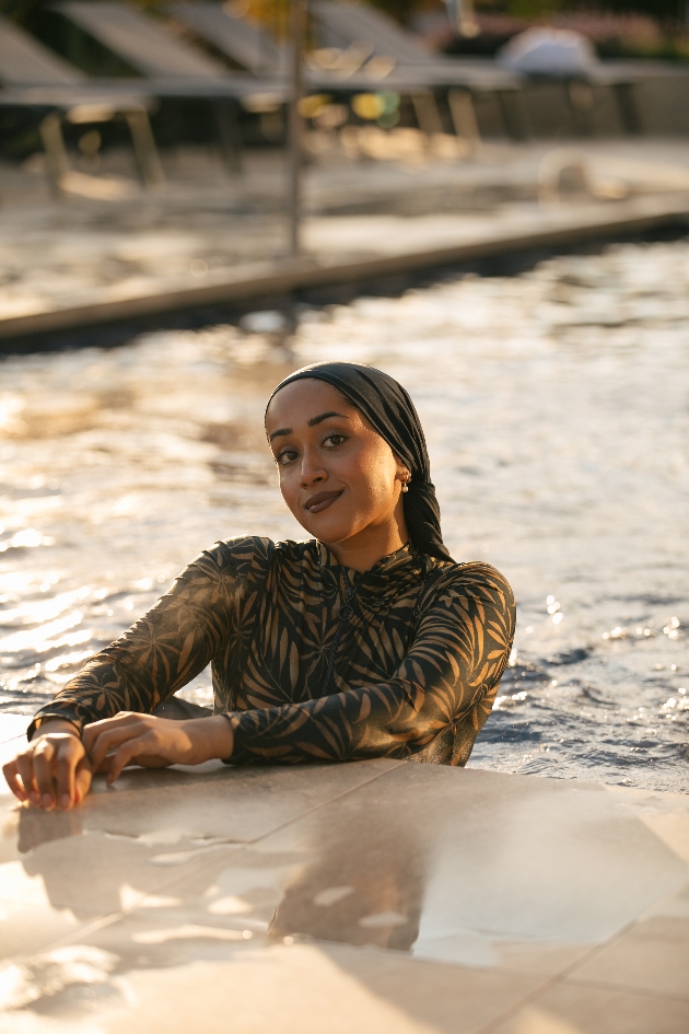 Lady in the pool wearing LYRA Swim with a leaf pattern.
