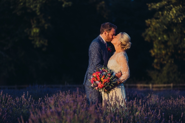 Bride and groom kissing in lavender field at Swettenham Arms