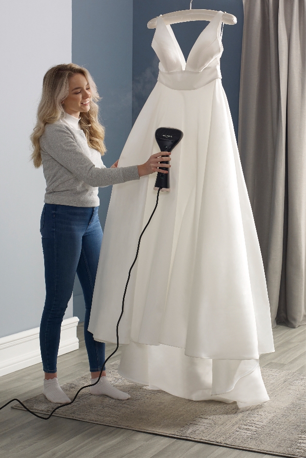 woman steaming a wedding dress