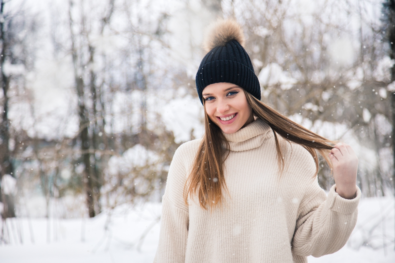 woman in snow in bobble hat with long hair