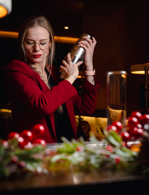 woman with cocktail shaker at bar