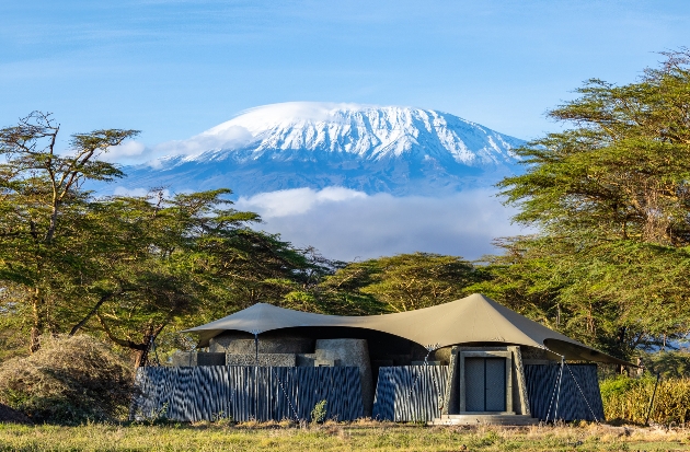 A tent in the wilderness with a large mountain behind it