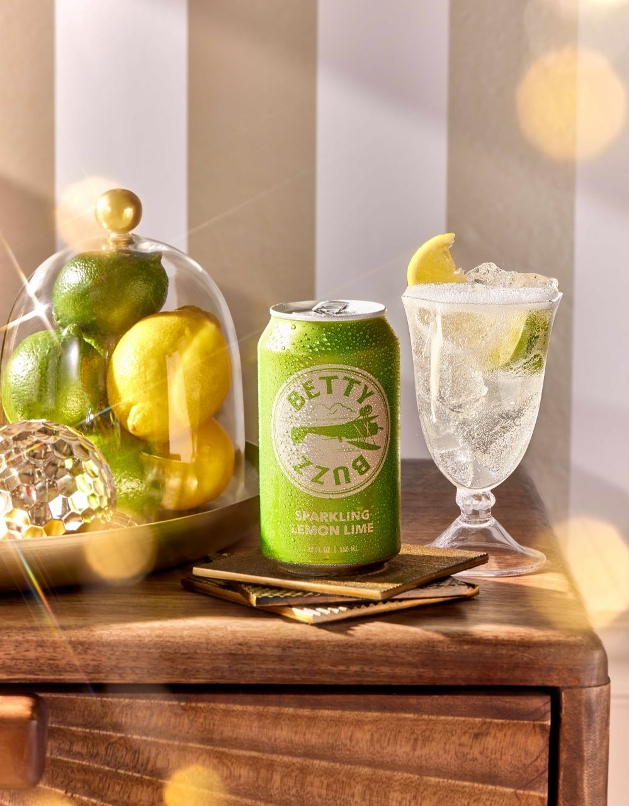 Betty Buzz green can on table with lemon and limes in a jar