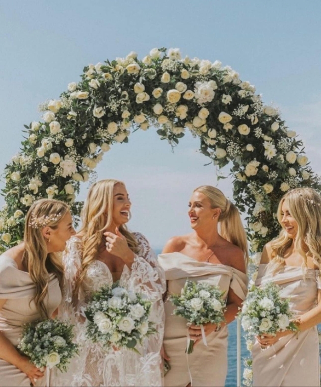 Bride and bridesaids in fron of flower moon gate