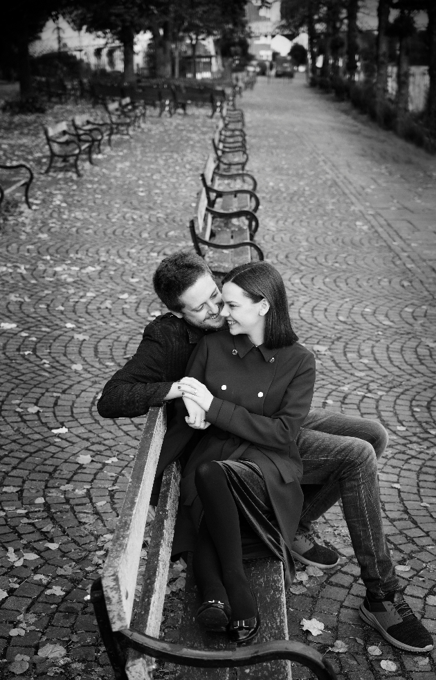 black and white image of a couple sitting on a park bench - engagement shoot