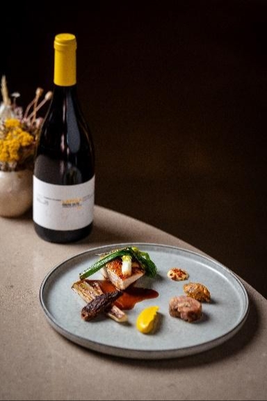 example of fine dining meal available at Manifest Liverpool with bottle of wine in the background