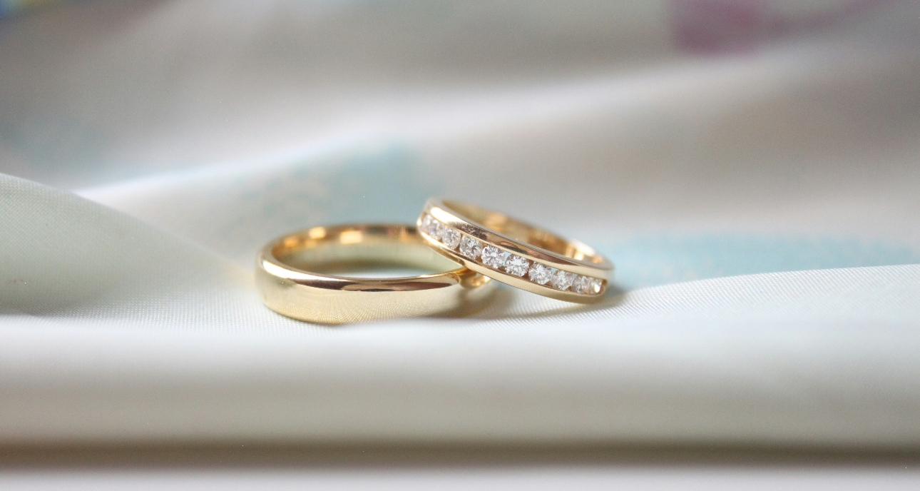 two gold wedding bands, one plain one diamond set